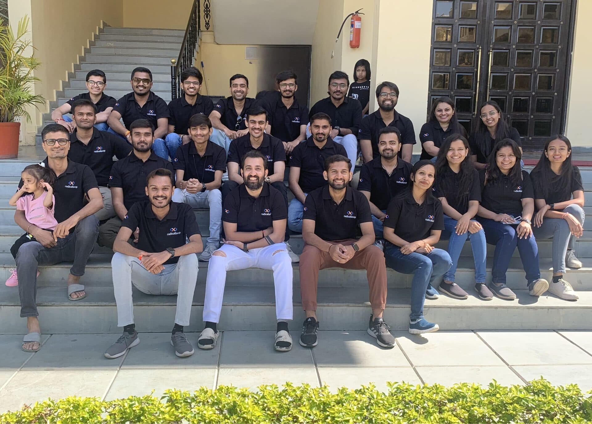 The RadicalLoop team sitting together on the office steps in Ahmedabad